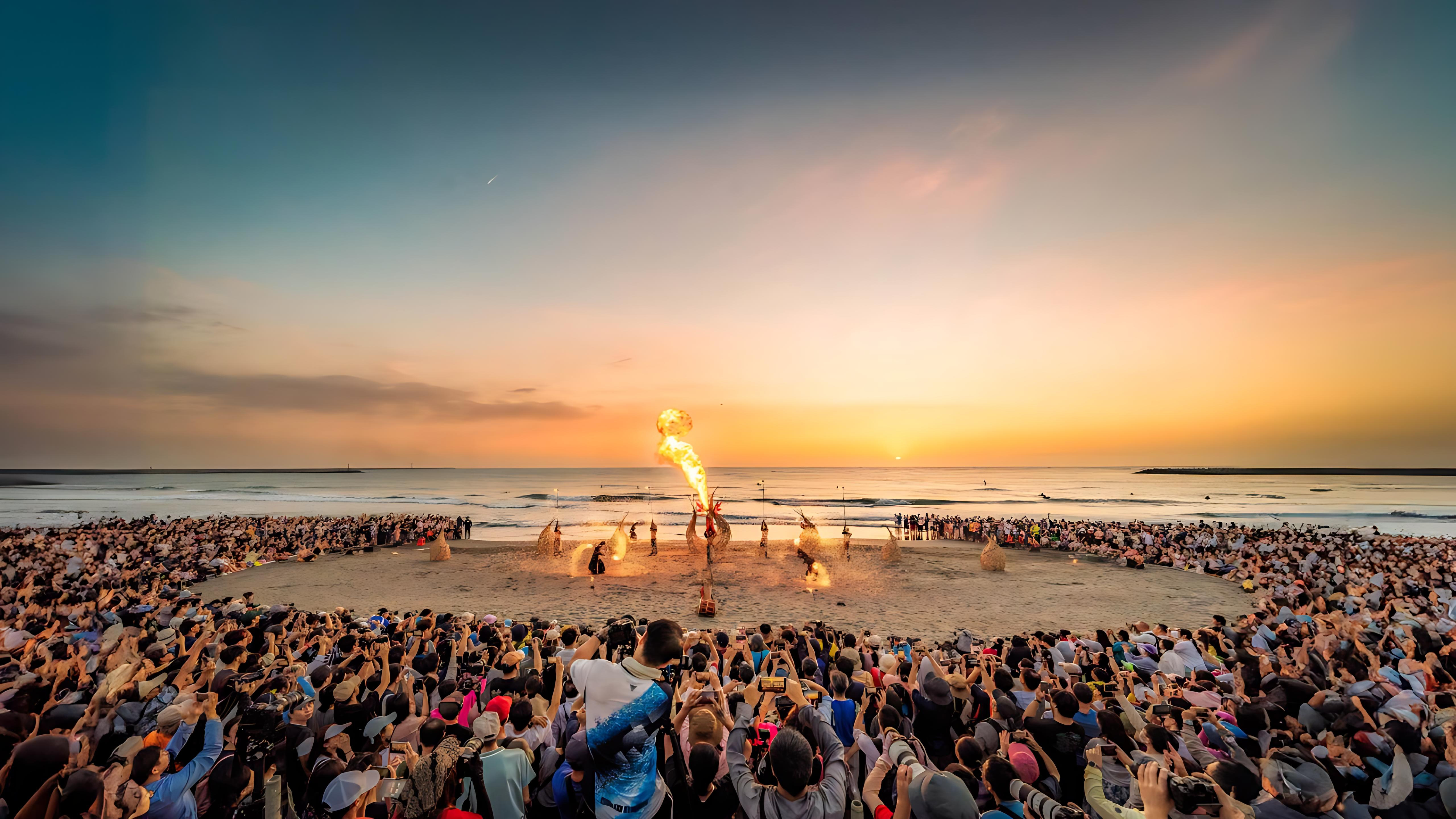 國際火舞藝術節在落日的海邊進行表演，周圍聚集眾多觀眾
