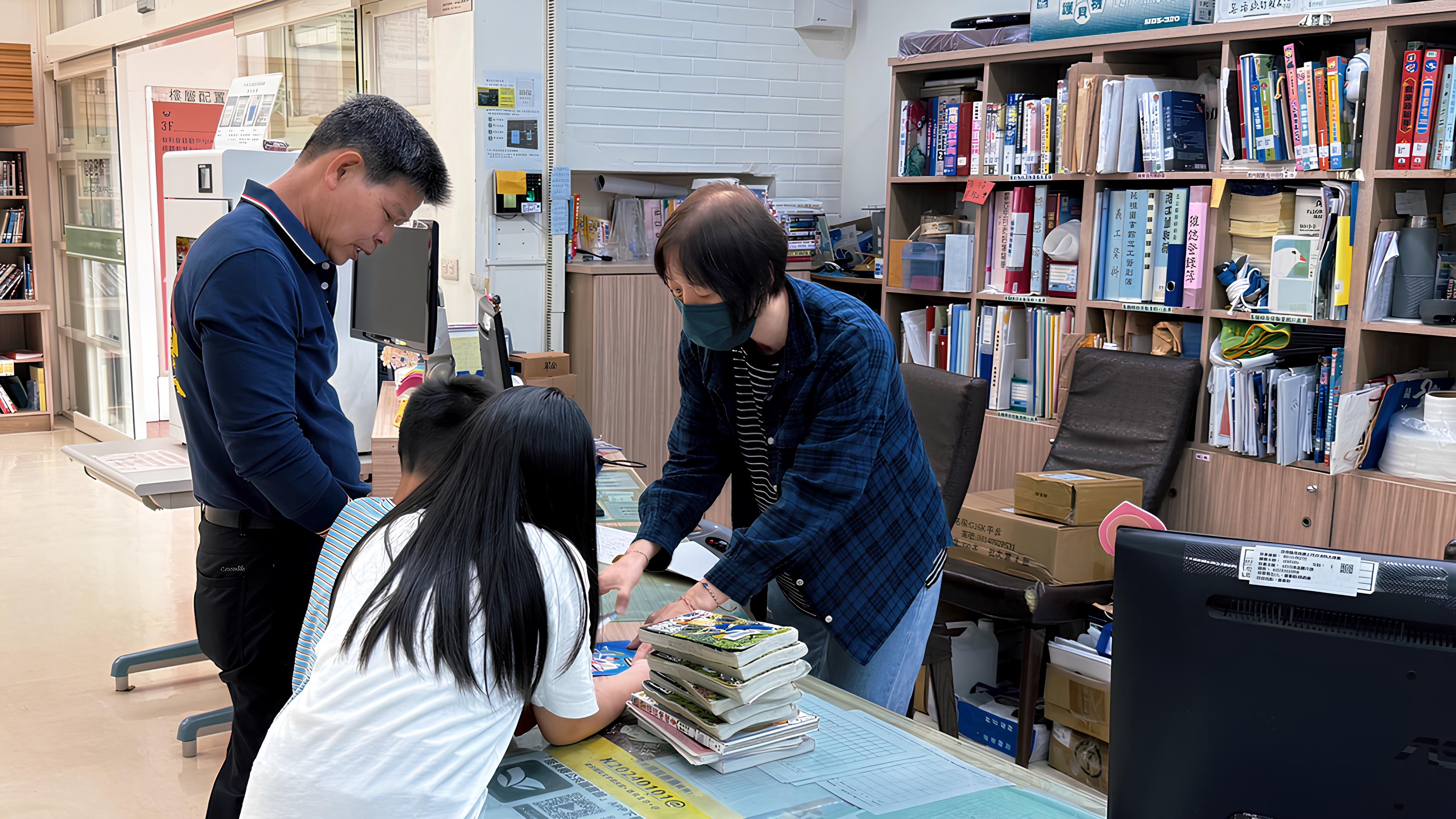 家長帶著孩子在櫃台辦理圖書借閱手續,桌上堆疊多本準備借出的書籍。