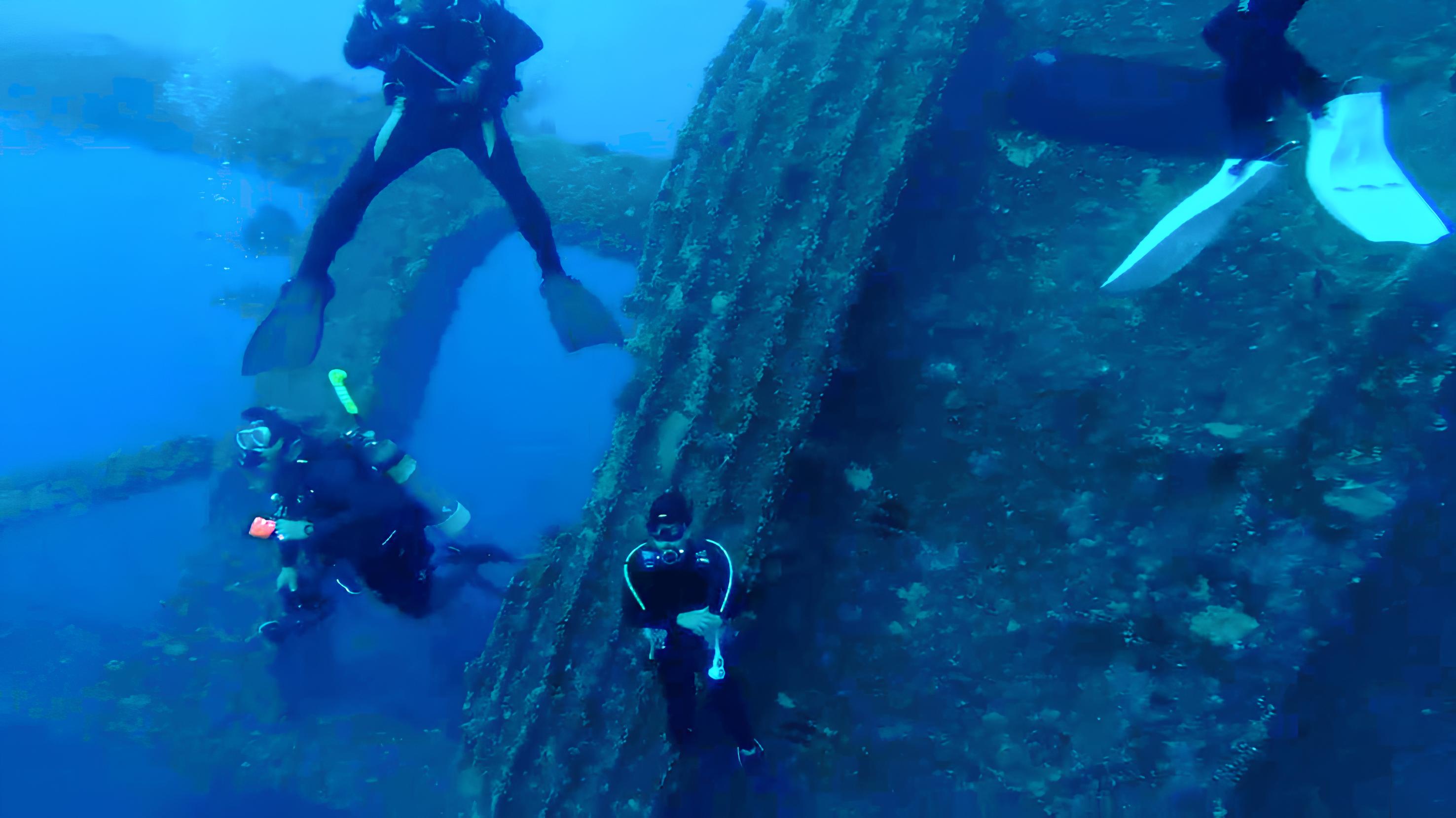 四位潛水員在堡壘號的殘骸旁