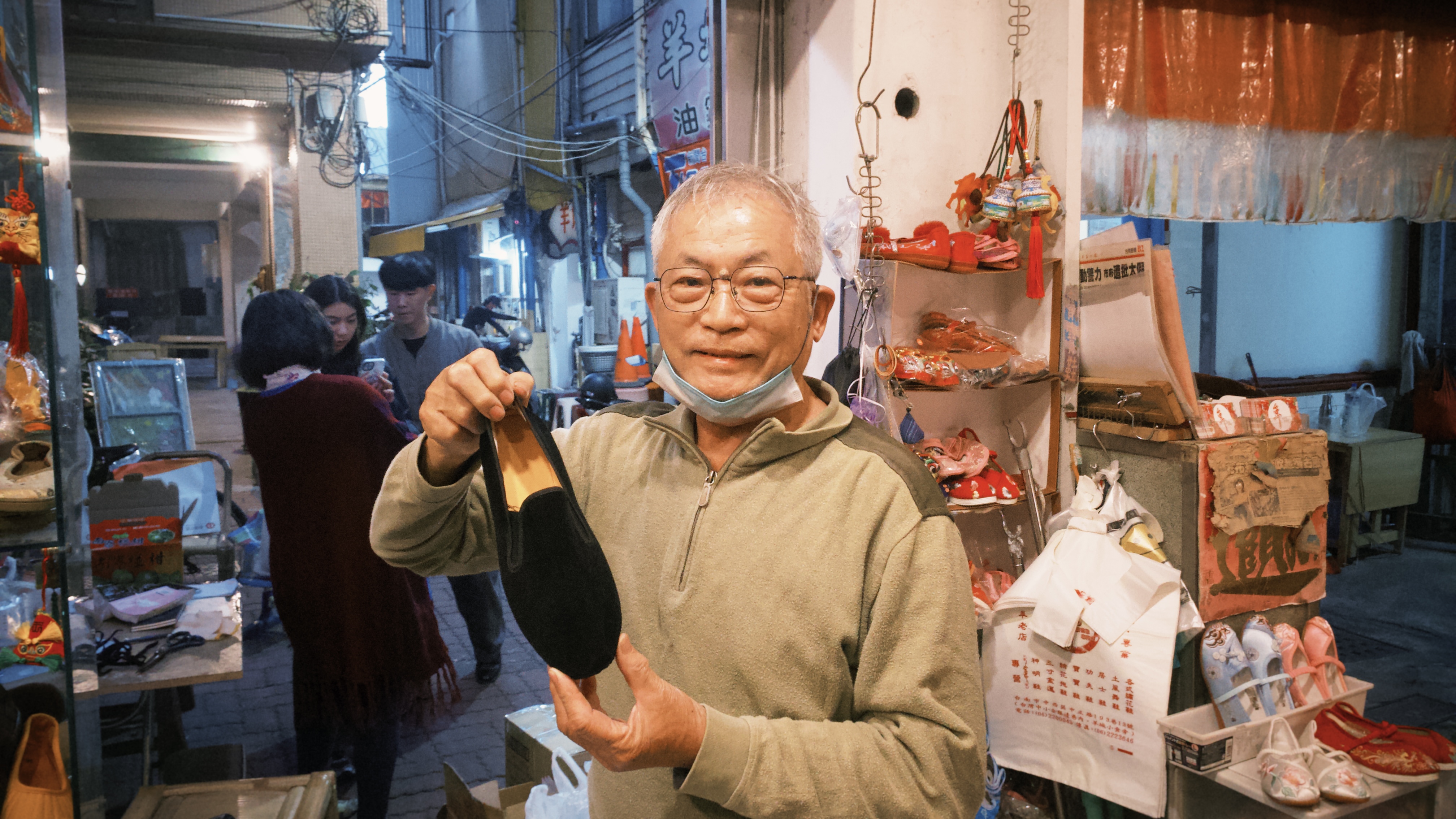 老闆李東志手上拿著一隻功夫鞋