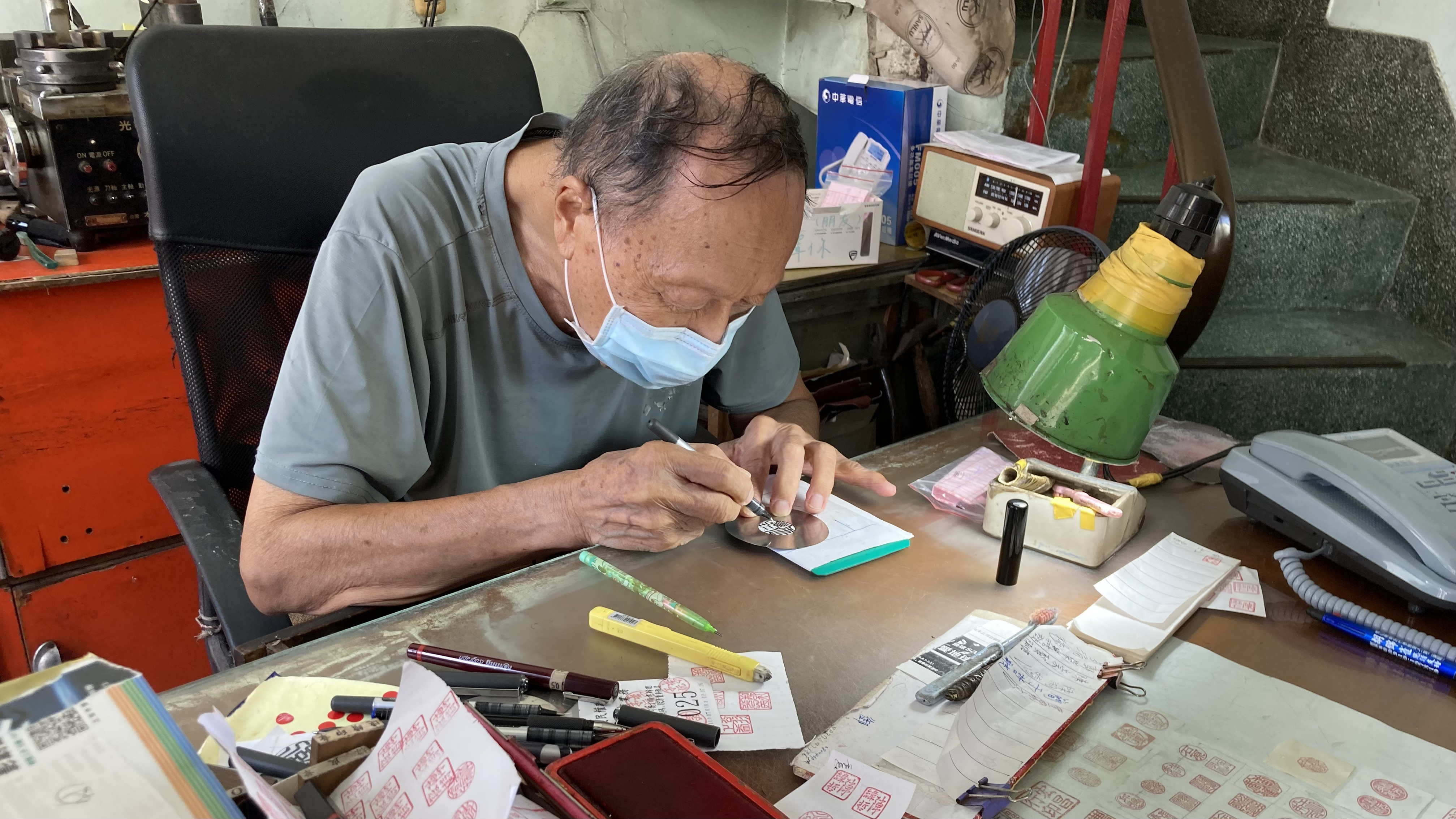 許振益師傅坐在桌前低頭寫字