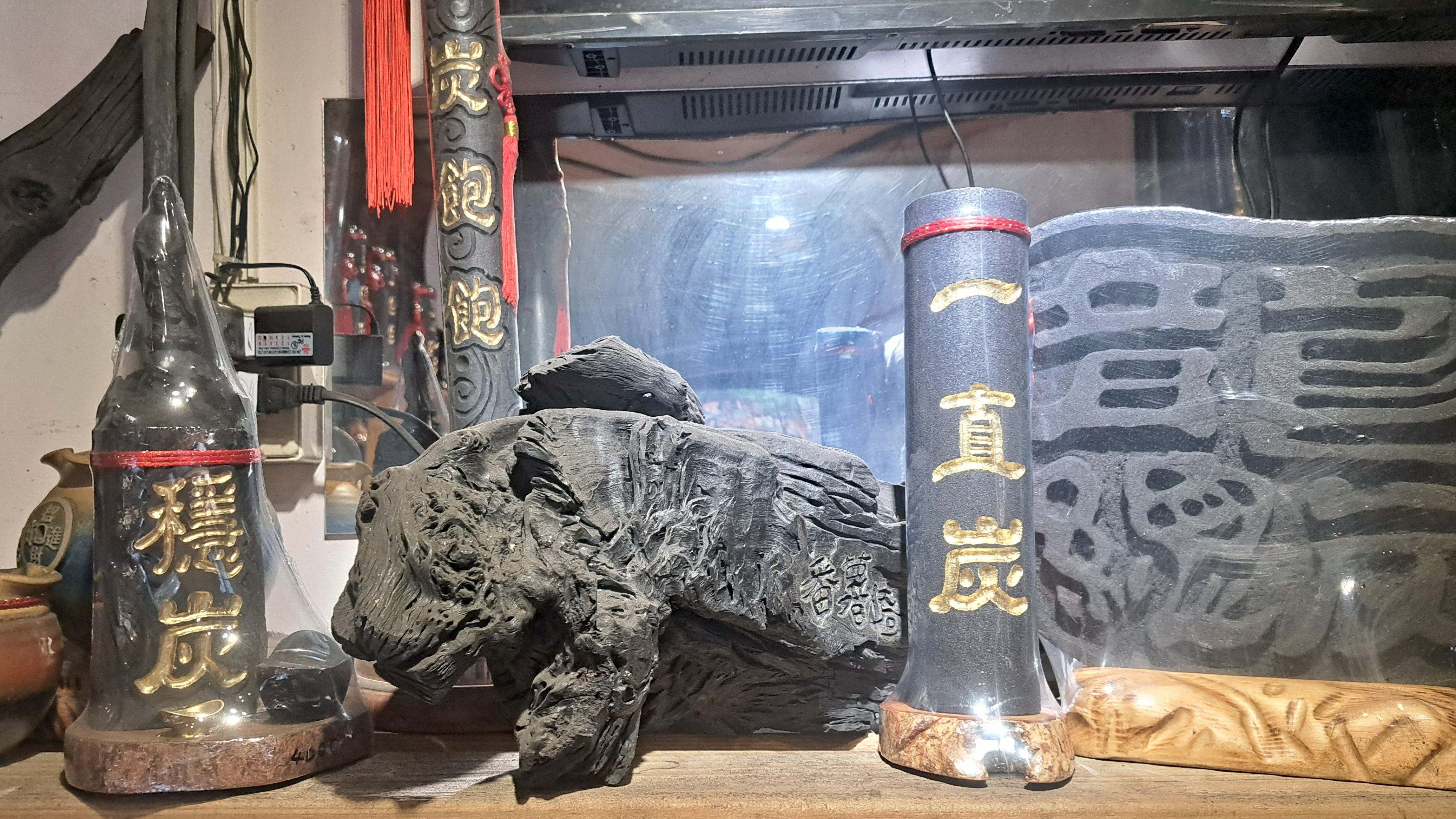 多件擺放在木架上的木炭雕刻與裝飾藝術品