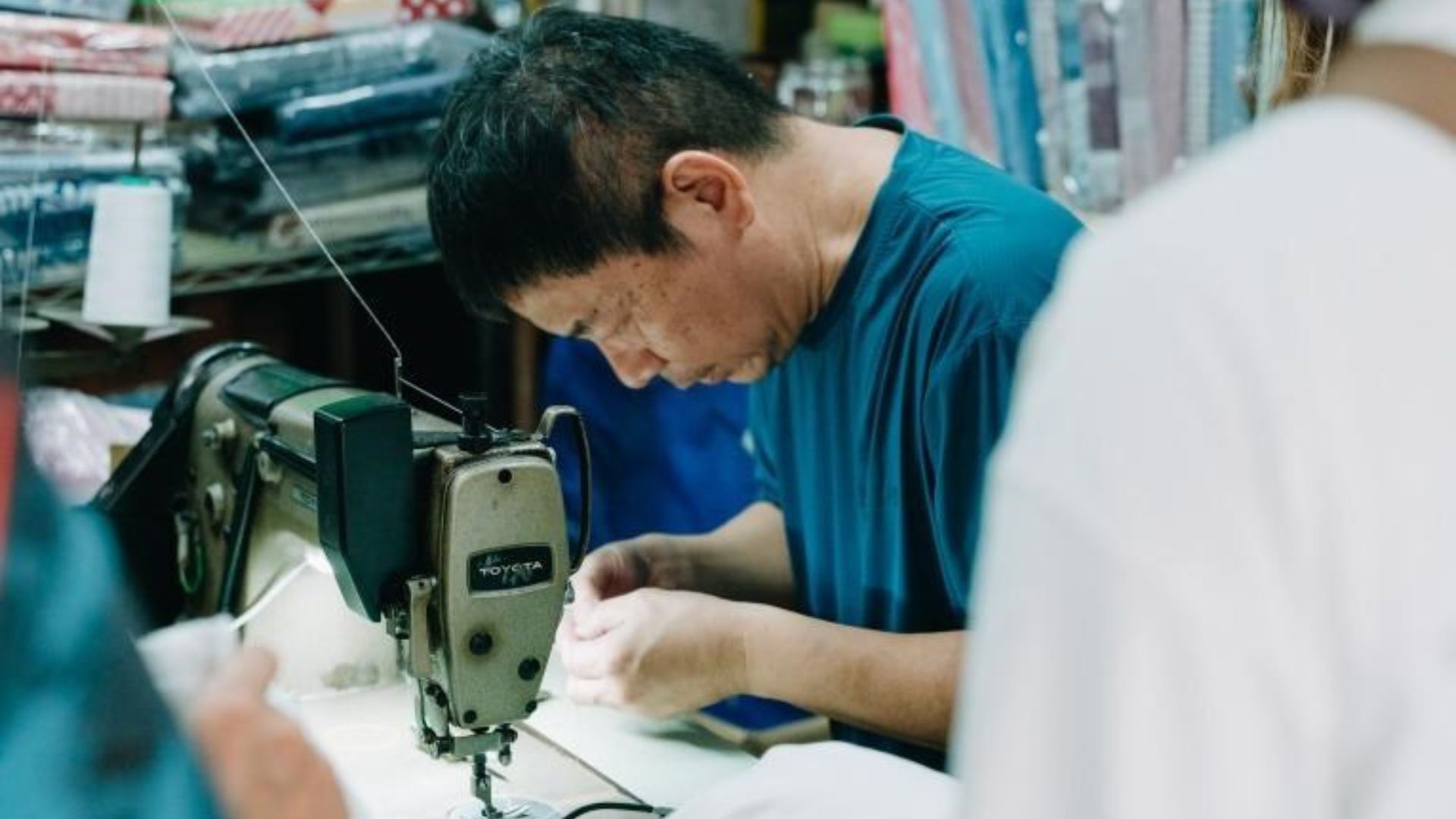 老闆進行手工棉被製作流程中最後針縫的專注神情
