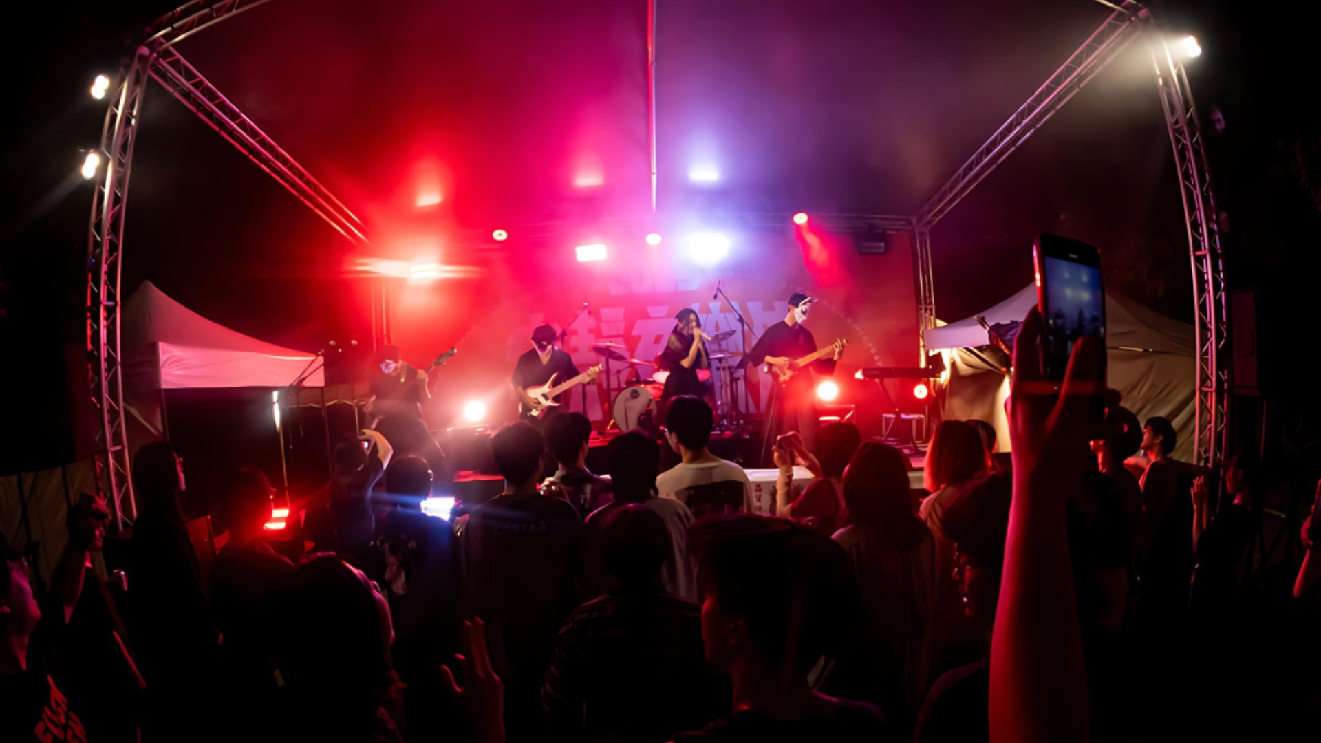 學生組成的樂團在寧靜音樂節的舞台上表演，台下有許多觀眾