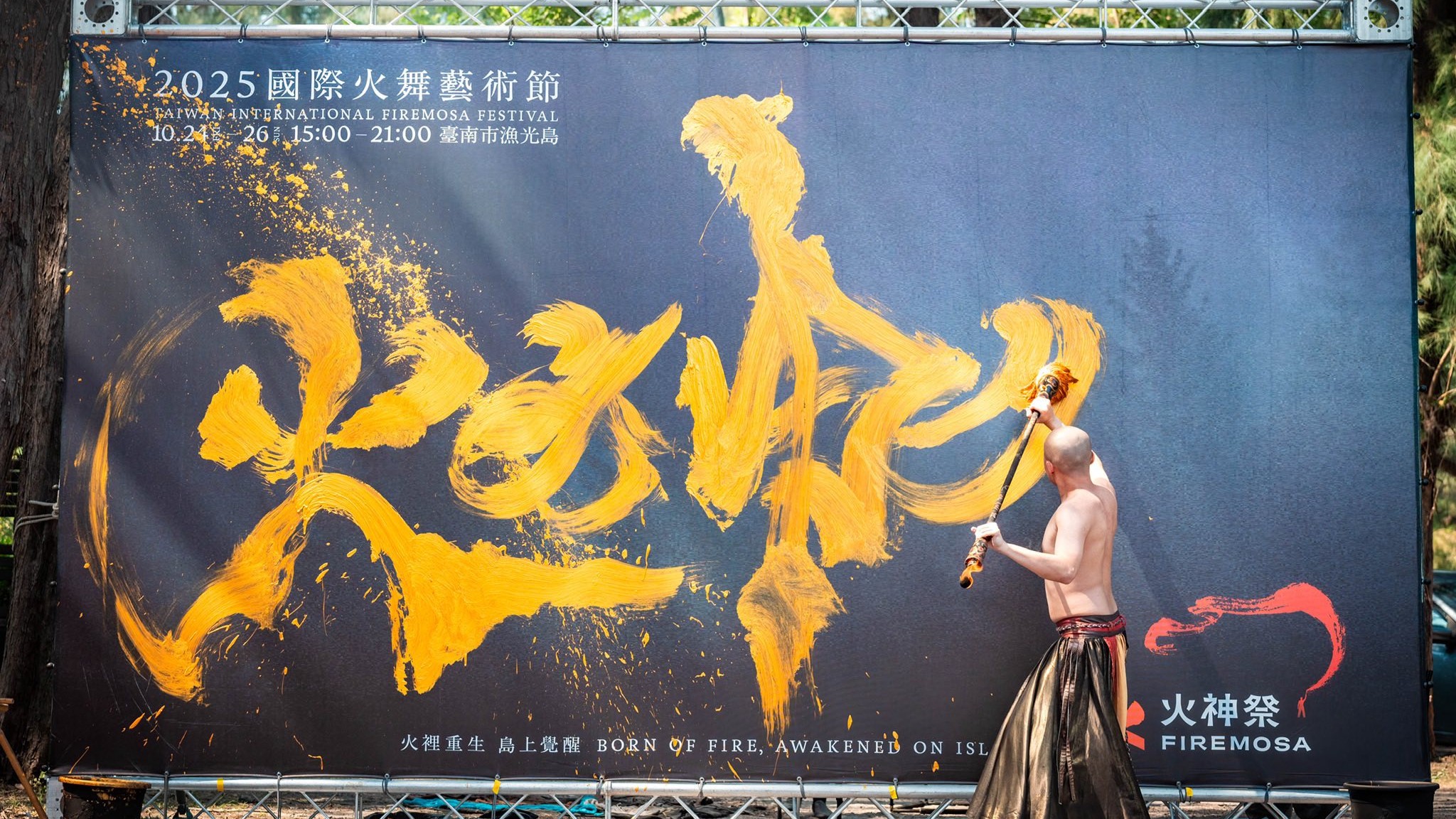 蔡宏毅在2025國際火舞藝術節的看板上寫下「火神」二字