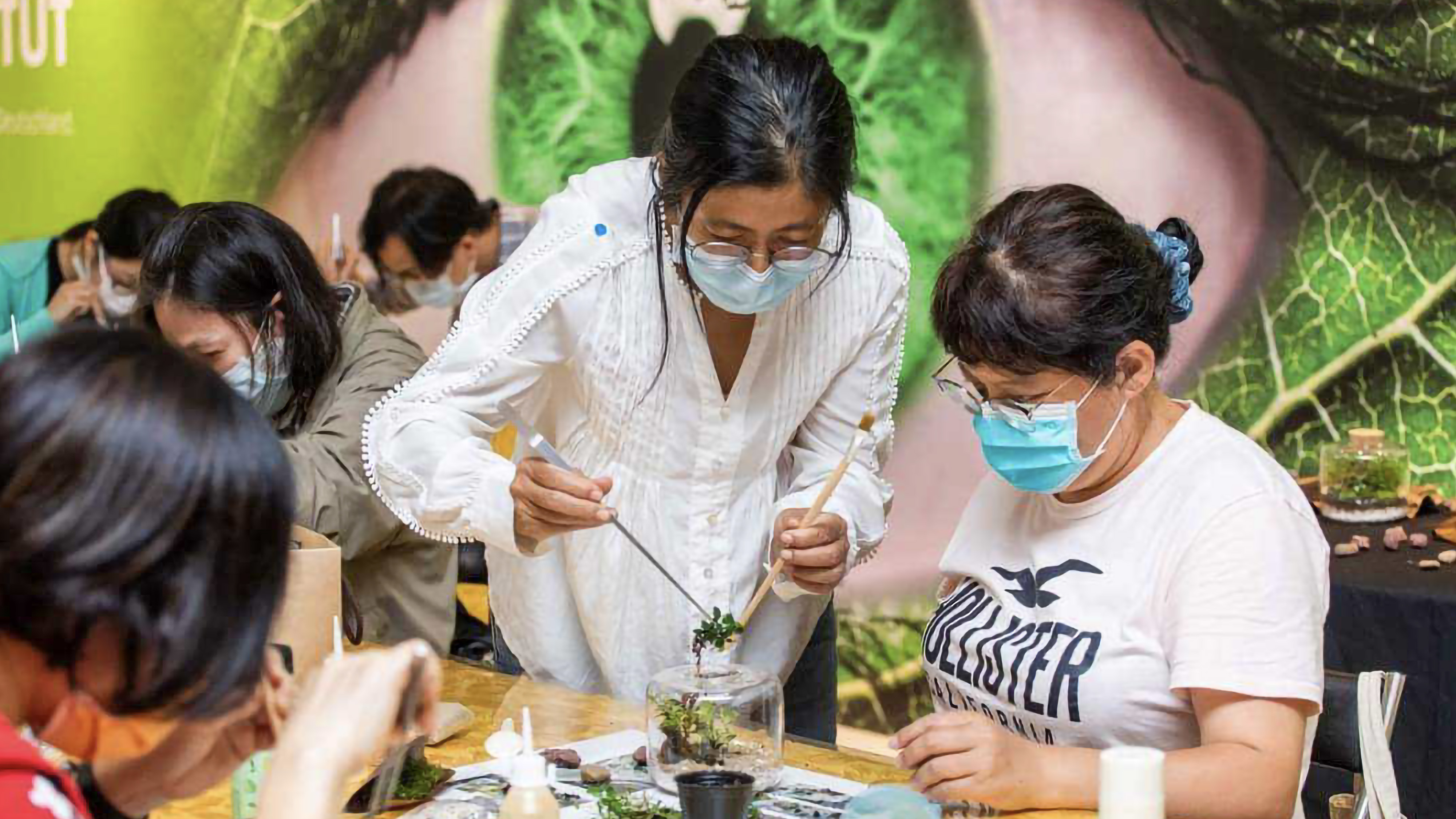 羅如蘭在學員身旁教導學員如何製作生態瓶