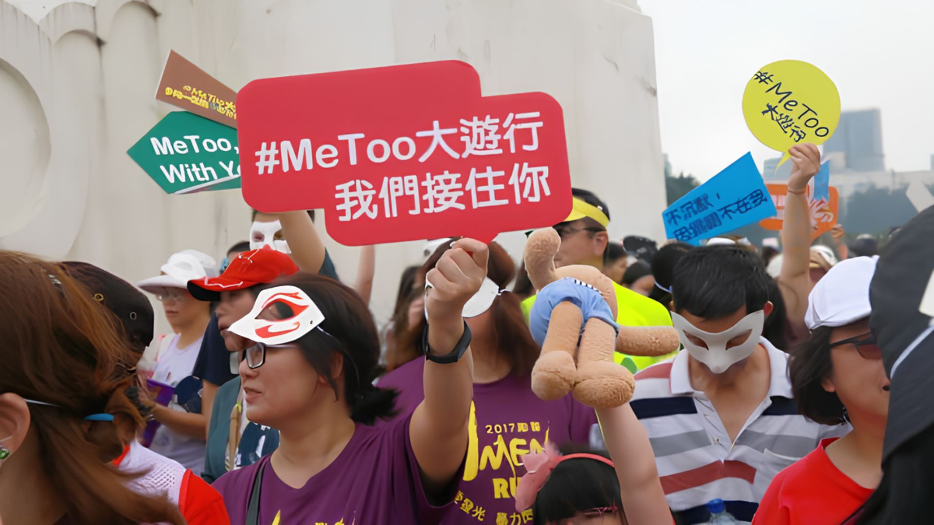 民眾遊行拿著「#MeToo大遊行我們接住你」的牌子