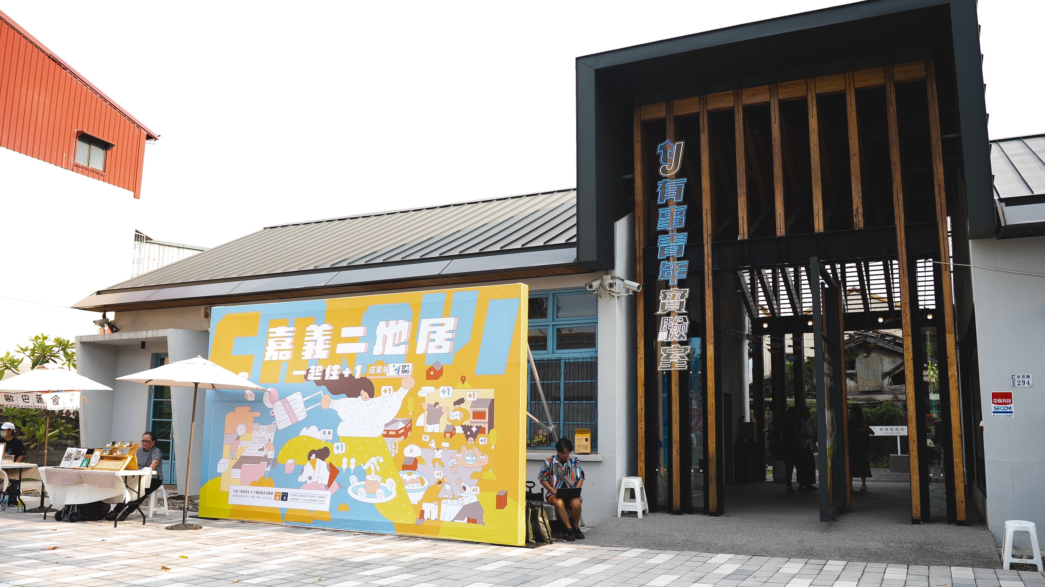 有事青年實驗室門口的「嘉義二地居一起住+1成果展」的主視覺看板