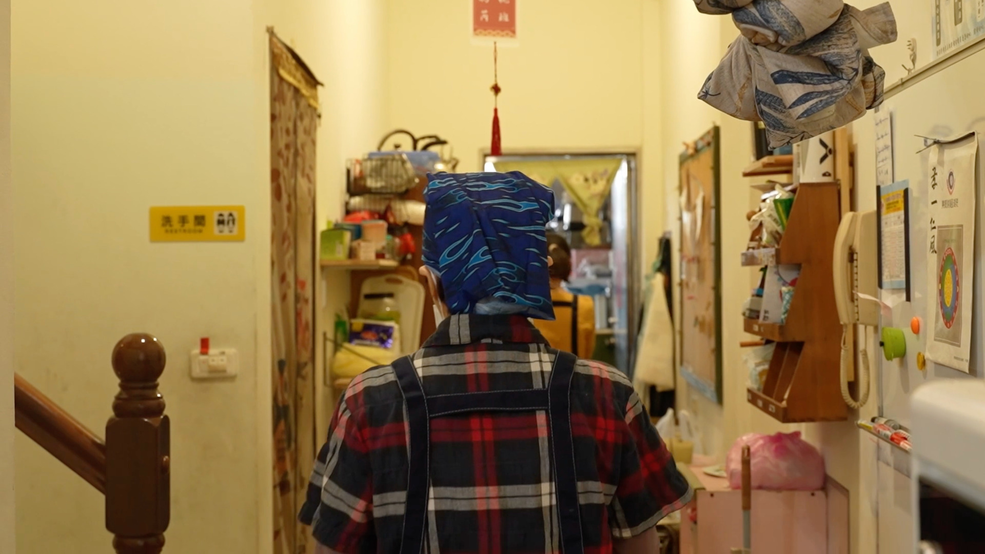 一個頭戴頭巾身穿格紋襯衫的女性背影