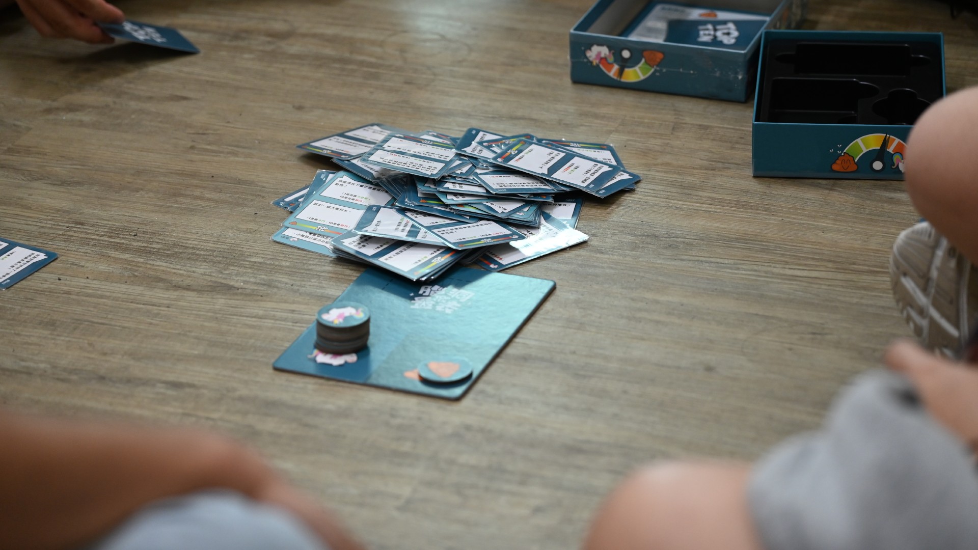 一群人正在遊玩實際解謎遊戲，中間堆放著一疊卡牌