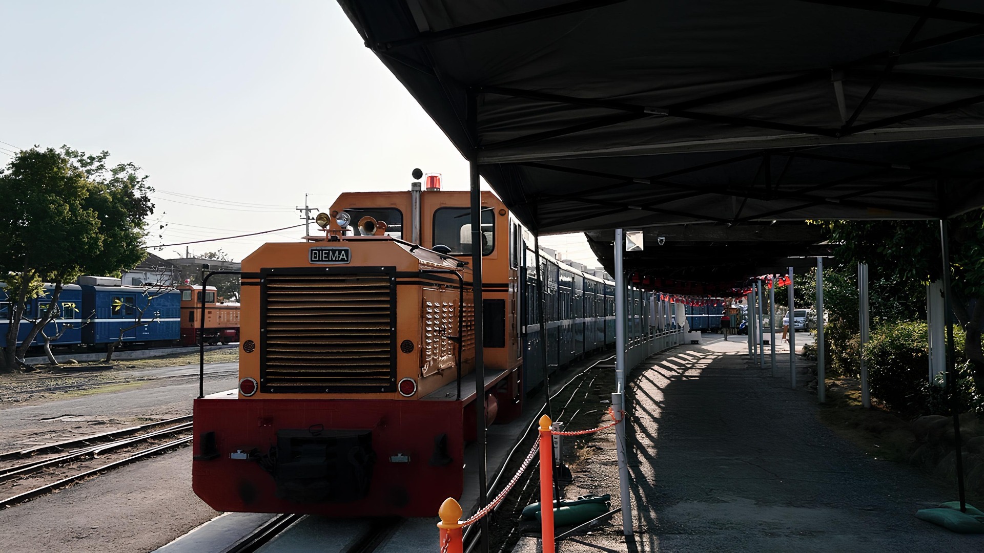 一列橘黃色的火車停靠在月台邊。