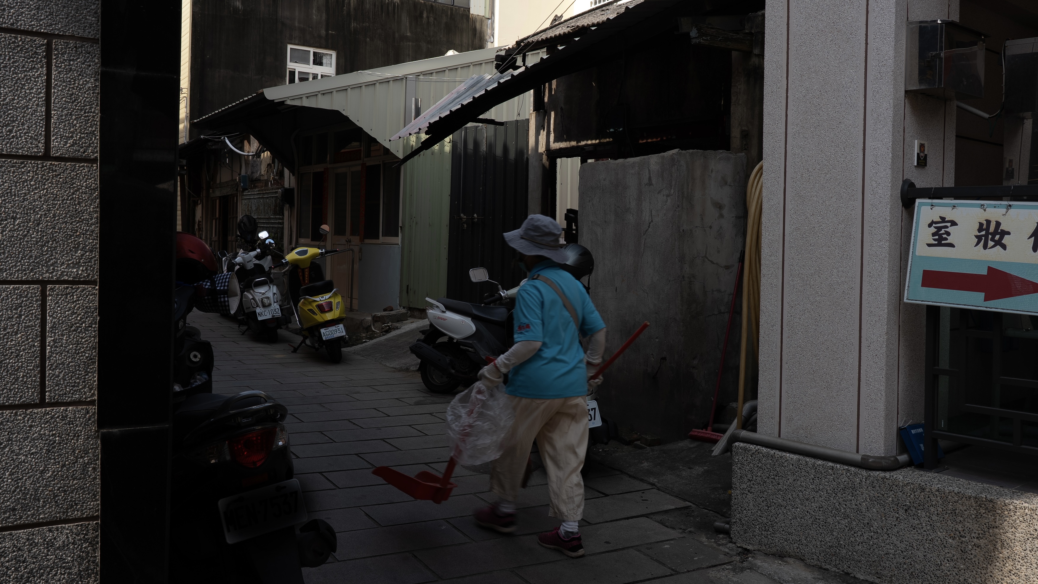 一名香客大樓的工作人員走在巷弄中