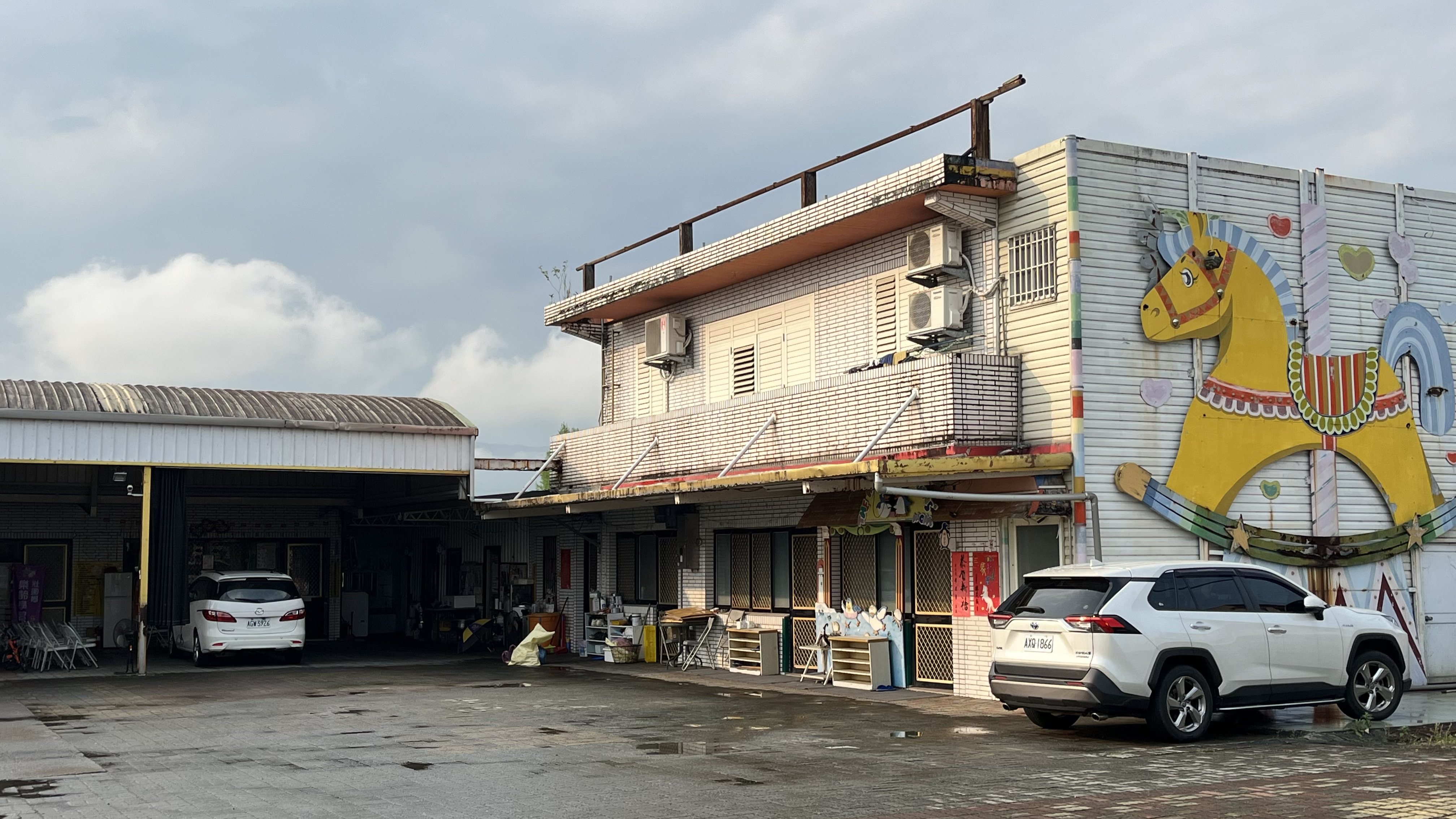 白色外牆上裝飾著巨大的黃色搖搖馬圖案。