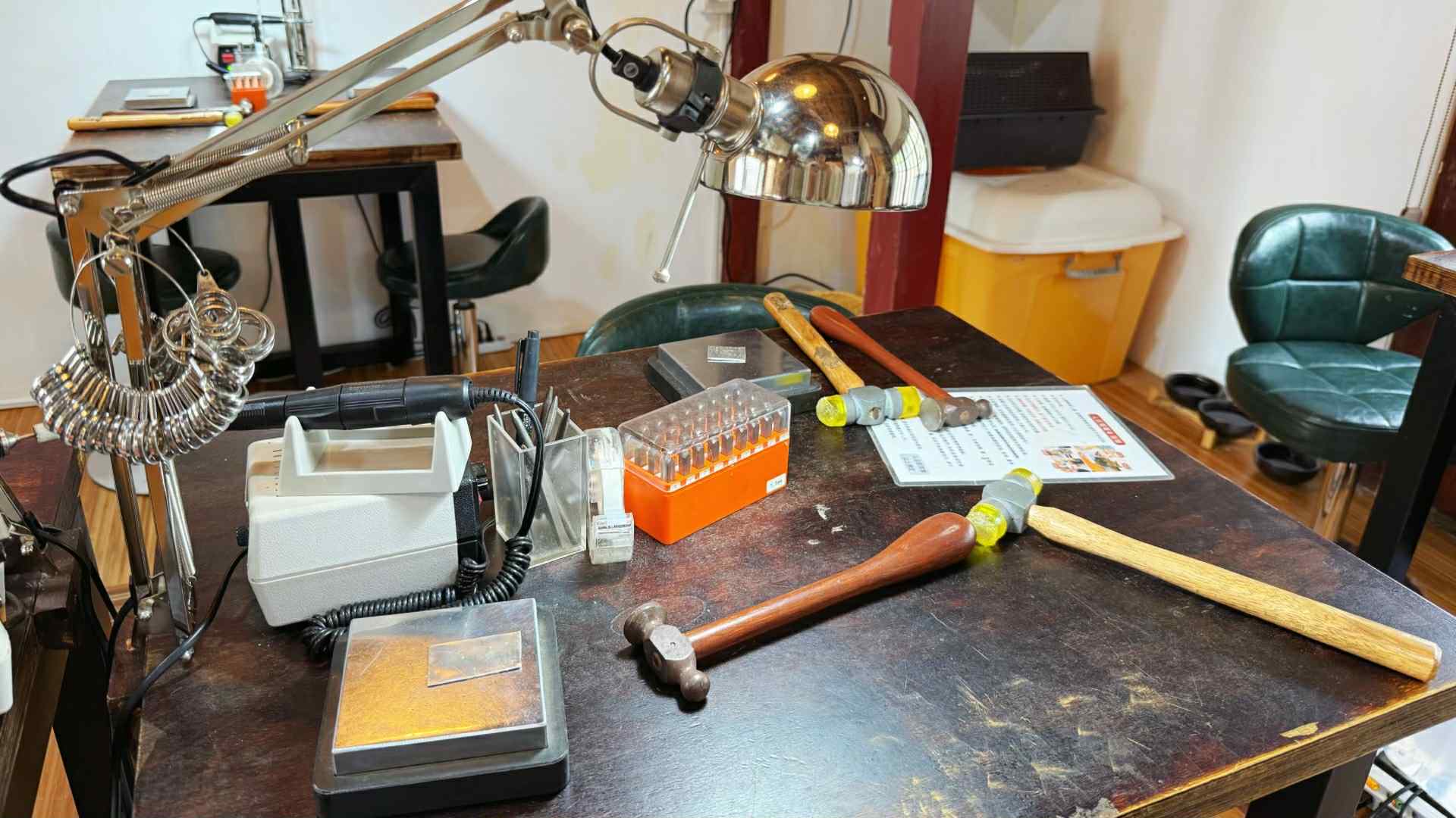 桌上擺放錘子、檯燈與各種用具