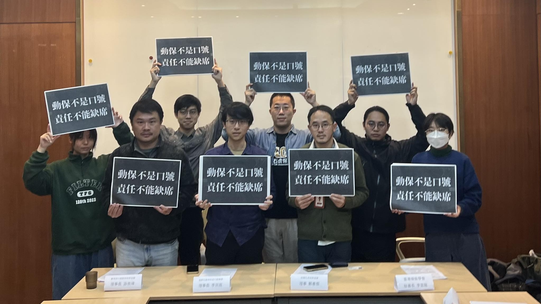 八位人士並排站立,手中舉著寫有「動保不是口號,責任不能缺席」的黑底白字標語,表達訴求。
