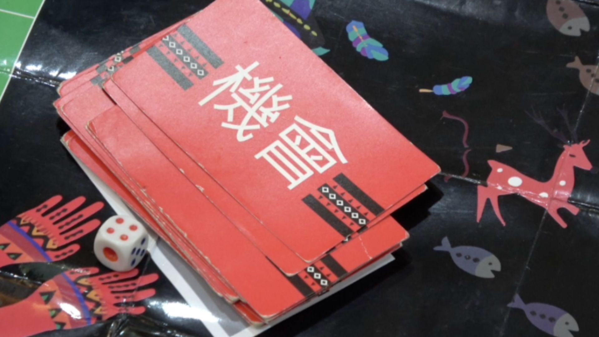 一套帶有原住民族圖騰設計的桌遊「機會」卡牌與骰子