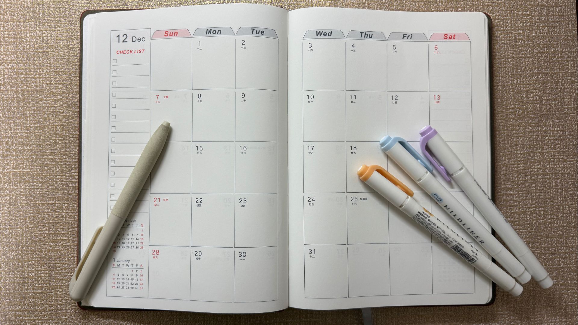 月計劃本與三隻不同顏色的螢光筆