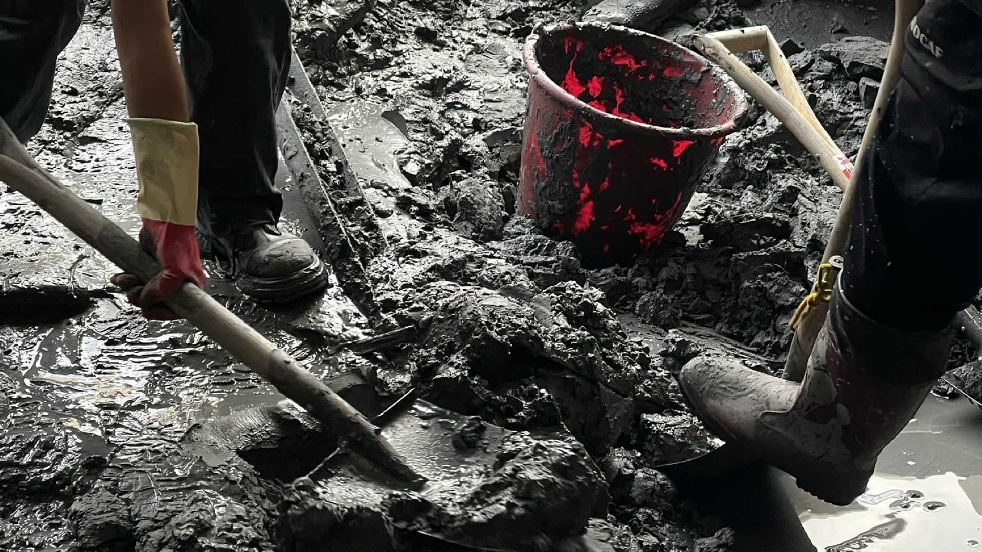 志工們手持鏟子正在挖泥土