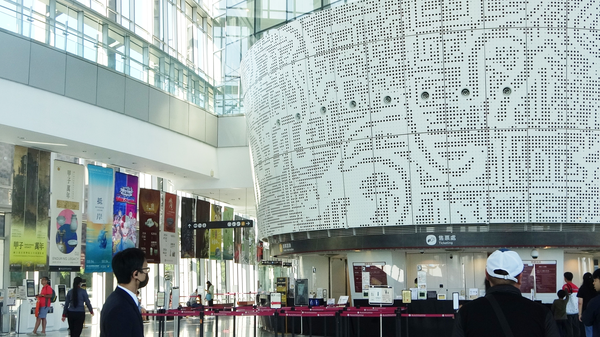 售票大廳內有少數民眾，窗邊掛著許多不同展覽的布條