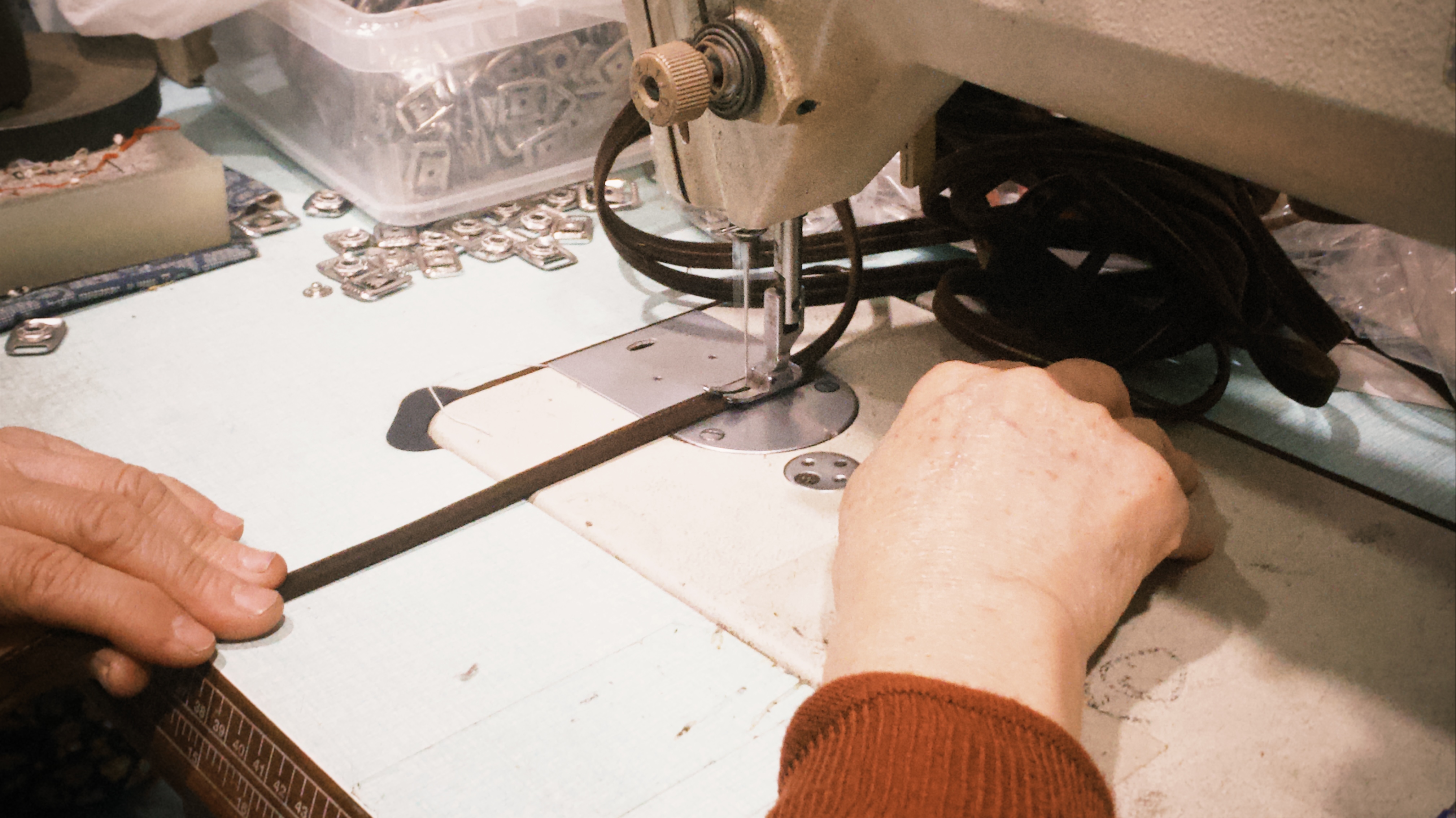 特寫師傅用裁縫機縫製一條鞋帶