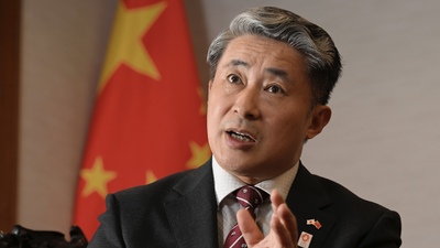 薛劍正在台上發言,後方放著一面中國國旗