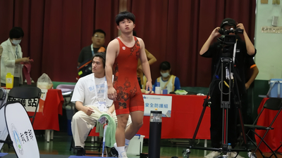 一名穿著紅色連身角力服的年輕男性運動員