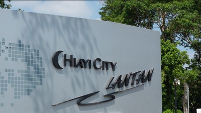 一面戶外的灰色地標牆，上面鑲嵌著「CHIAYI CITY LANTAN」