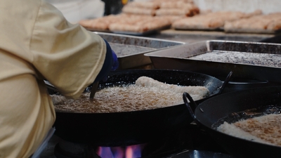 一位員工站在油鍋前炸肉卷